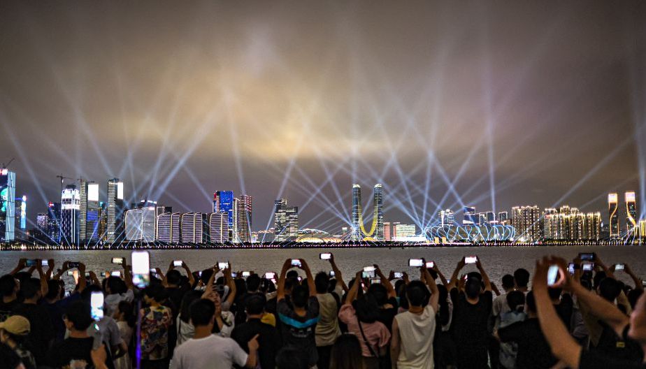 游客们汇聚钱塘江畔欣赏杭州城市阳台灯光秀